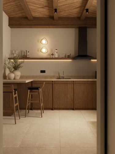 a kitchen with wooden cabinets and a counter with a sink at Salt and stone suites in Vrachonisída touArchangélou