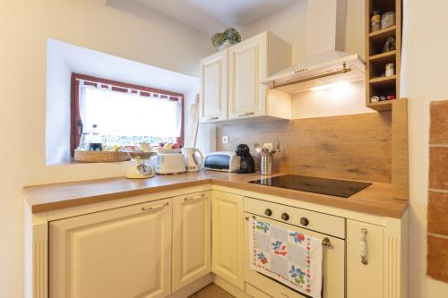 a kitchen with white cabinets and a sink at Herbal Garden Resort Plahtica in Jurklošter