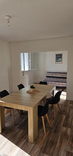 a dining room with a wooden table and chairs at Appartement T4 proche gare in Guingamp