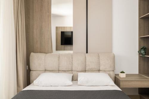 a bedroom with a bed with a headboard and a television at D & D Apartments in Kassandra