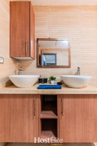 a bathroom with two sinks and a mirror at Appartement Central Park - Clim - 10 min plage in Mohammedia