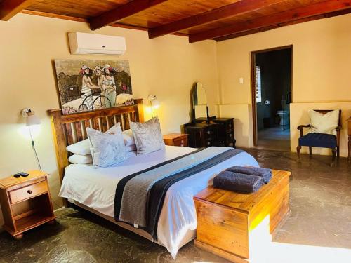 a bedroom with a large bed and a chair at Travalia Guest Farm in Nelspoort
