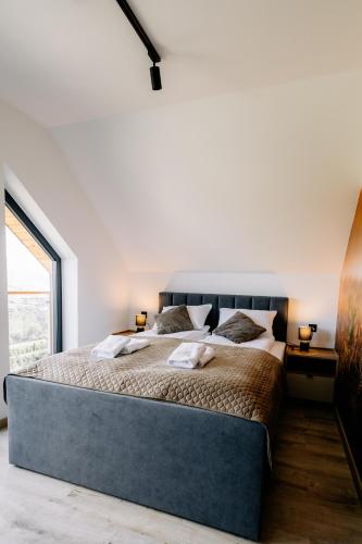 a bedroom with a large bed and a large window at Za Łyską - Żywiecka Perła in Żywiec