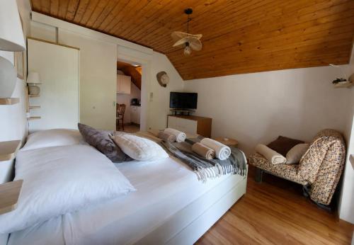 a bedroom with a large white bed and a chair at Terme Olimia - Apartment Lipa 112 in Podčetrtek
