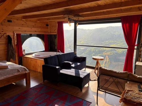 a living room with a couch and a large window at ONASUITBUNGALOW in Rize