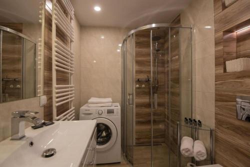 a bathroom with a sink and a washing machine at Apartment Mountain Panorama in Wisła
