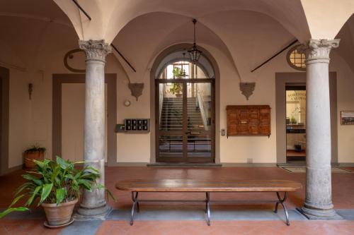 a table in the middle of a room with columns at Foresteria Valdese di Firenze in Florence