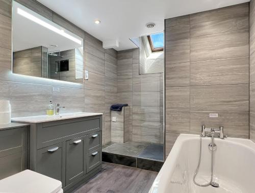 a bathroom with a tub and a sink and a bath tub at Whitley Farm Molland in Molland