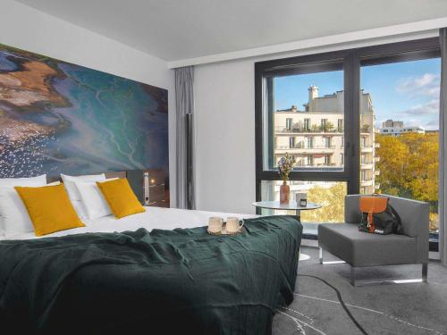 a bedroom with a bed and a chair and a large window at Novotel Paris Porte Versailles in Paris