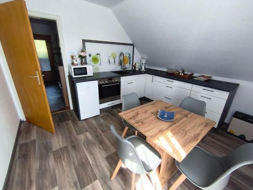a small kitchen with a wooden table and chairs at FeWo Rina in Pottenstein