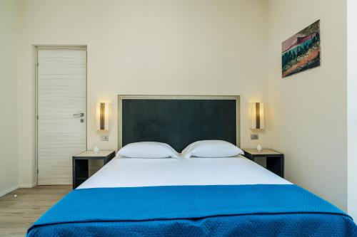 a bedroom with a large white bed with two tables at Viscuso House B&B in Aci Castello