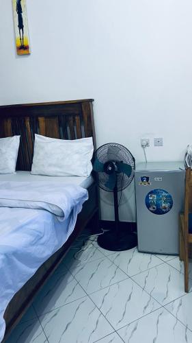 a bedroom with a bed and a fan next to it at Osim bnb 2 in Arusha