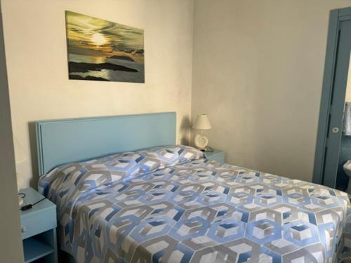 a bedroom with a bed and a painting on the wall at Azzurrina in Marettimo