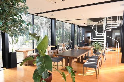 a dining room with a table and chairs and plants at SENJA Dewata in Mitoyo