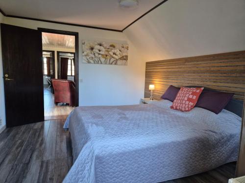 a bedroom with a large bed with a wooden headboard at Stenberg Nature Residence in Tyringe