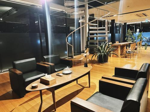 a lobby with chairs and a table and a staircase at SENJA Dewata in Mitoyo