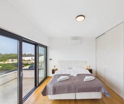 a bedroom with a large bed and a large window at Vila Volme in Banjole
