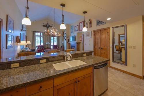 a kitchen with a sink and a living room at The Lodge at Mountaineer Square, A Vail Resorts Property in Mount Crested Butte