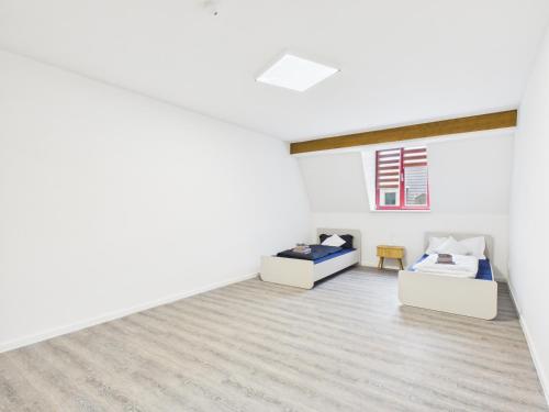a white room with two beds and a window at Landeskron38 - LK38 in Görlitz