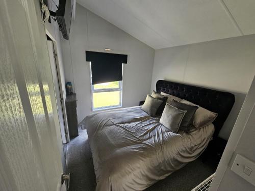 a bedroom with a bed with pillows and a window at Bwr27 in East Mersea