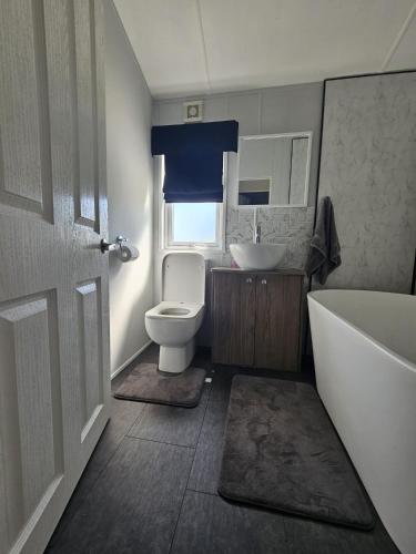 a bathroom with a tub and a toilet and a sink at Bwr27 in East Mersea