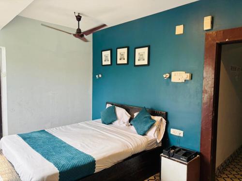 a bed in a room with a blue wall at Hotel Sundari in Guwahati