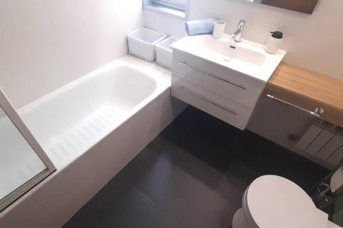a bathroom with a white tub and a sink at Apartamento Playa in Burela de Cabo