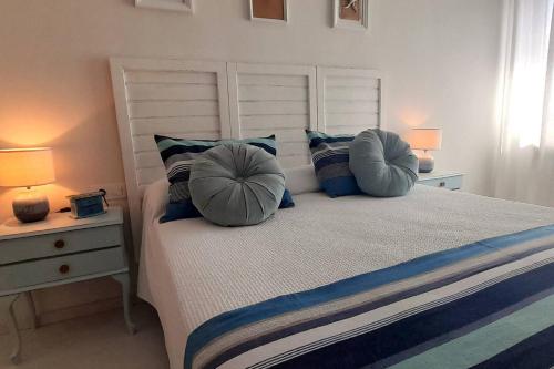 a bedroom with a large bed with pillows and two lamps at Apartamento Playa in Burela de Cabo