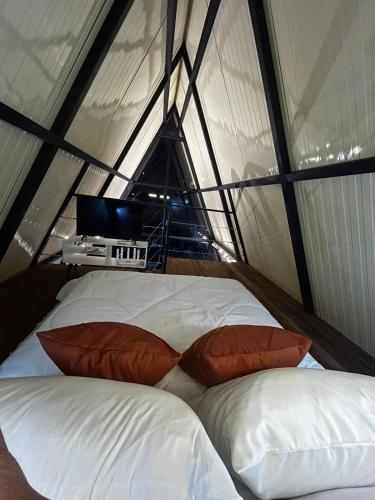 two beds in a tent with a tv in it at Chalés Alto Caparaó in Caparaó Velho