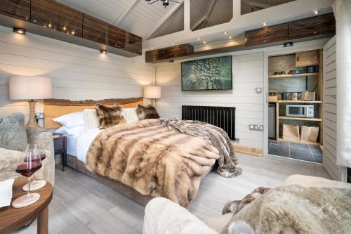 a bedroom with a bed and a fireplace at The High Longtail Lodge - Ridgestone in Bowness-on-Windermere