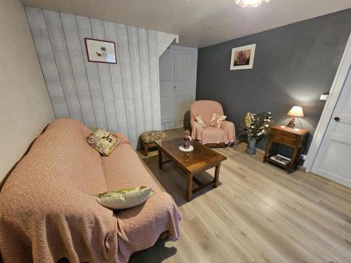 a living room with a bed and a table and chairs at La maison de preuillé in Payré