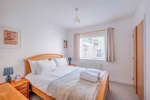 a bedroom with a large bed and a window at Comfortable Cottage with Decking in Castle Cary in Castle Cary
