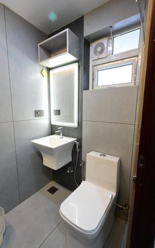 a small bathroom with a toilet and a sink at Aleida Residency in Cochin