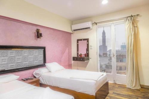 ein Hotelzimmer mit zwei Betten und einem Fenster in der Unterkunft Dell Celio Hotel in Kairo