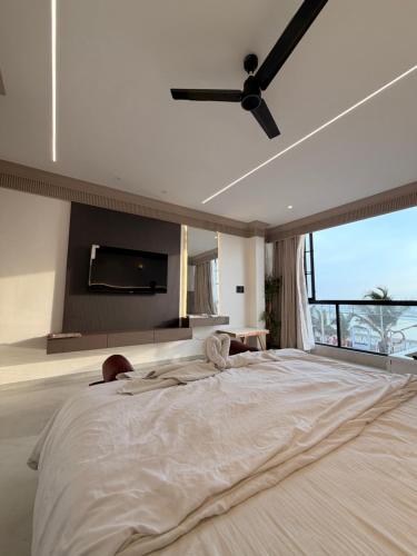 a bedroom with a large bed with a tv on the wall at Kshitij 5 bros in Vasai