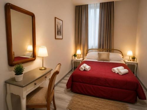 a bedroom with a bed and a desk with a mirror at casadiviaappia in Imola