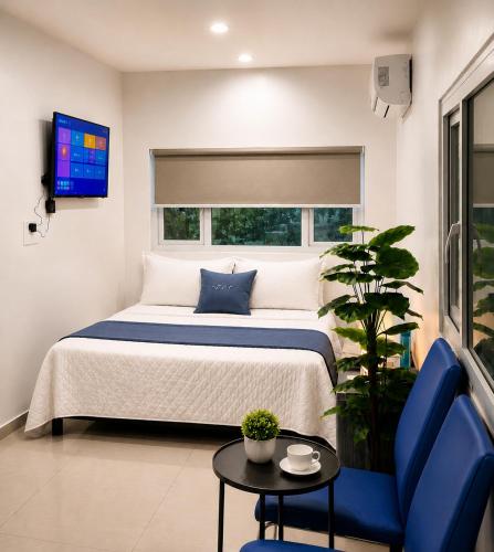 a bedroom with a bed with a blue chair and a table at The Onyx by 7 Valleys in Islamabad