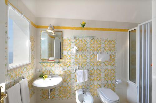 a bathroom with a toilet, sink, and tub at Palazzo Talamo in Positano
