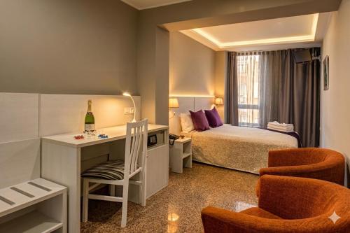 a hotel room with a bed and a desk with a chair at Hotel Nuevo Triunfo in Barcelona