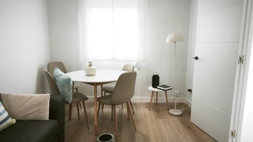 a white table and chairs in a small room at La Ilusión in Sanxenxo