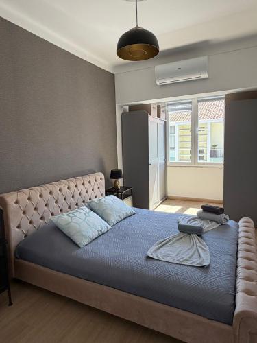 a bedroom with a large bed with a blue blanket at Cozy Apartment Almada in Almada