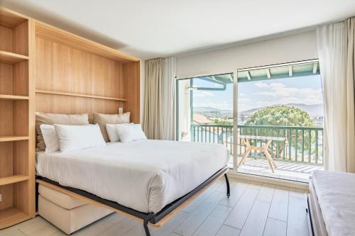 a bedroom with a large bed and a balcony at Résidence Ibaïa in Hendaye