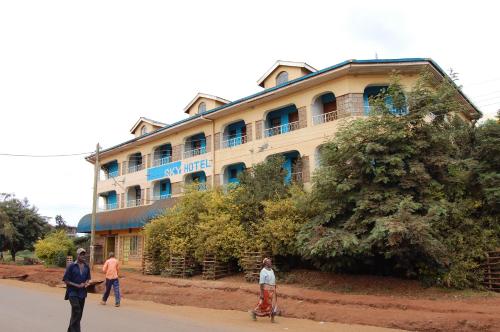 a group of people walking in front of a building at Sky Hotels Emali in Mwanda