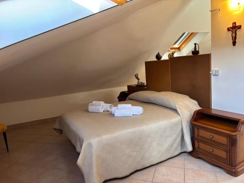 a bedroom with a bed with towels on it at il SOLE DELL' ALCANTARA in Gaggi