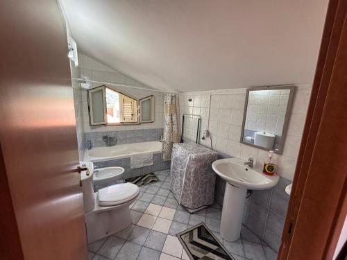 a bathroom with a toilet and a sink and a tub at il SOLE DELL' ALCANTARA in Gaggi