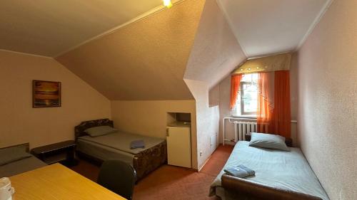 a small room with two beds and a window at Готельний комплекс «НАТАН» in Berezanʼ