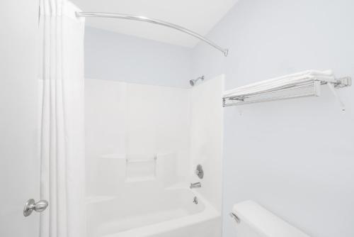 a white bathroom with a shower and a sink at Super 8 by Wyndham Van Horn in Van Horn
