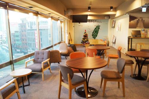 ein Restaurant mit Tischen und Stühlen und einem Weihnachtsbaum in der Unterkunft Trip GG Hostel in Kaohsiung