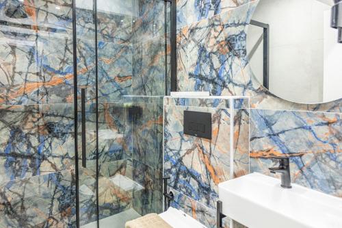 a bathroom with two sinks and a mosaic wall at Ernest Suites Monastiraki in Athens