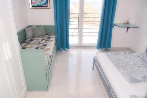 a room with two beds and a window with blue curtains at Hostel & Private Rooms Dalmatia in Marusici 